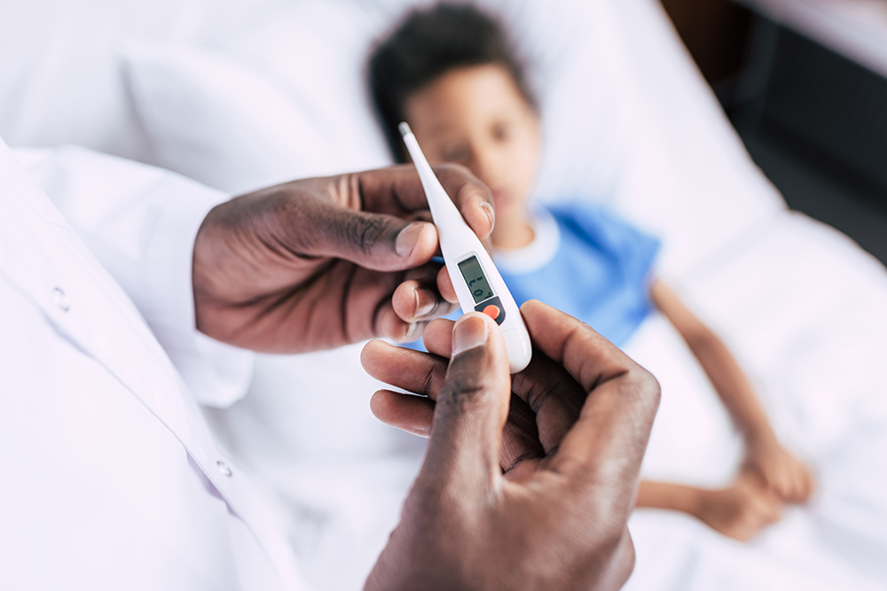 partial view of african american doctor holding electronic therm